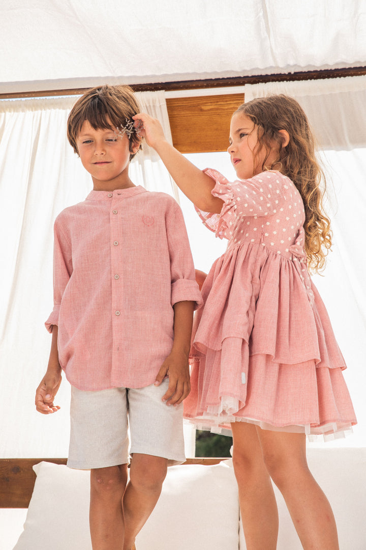 A delicate petal pink woven shirt by Tutto Piccolo, tailored for boys, merging classic design with a touch of summer flair, suitable for both casual and formal wear.